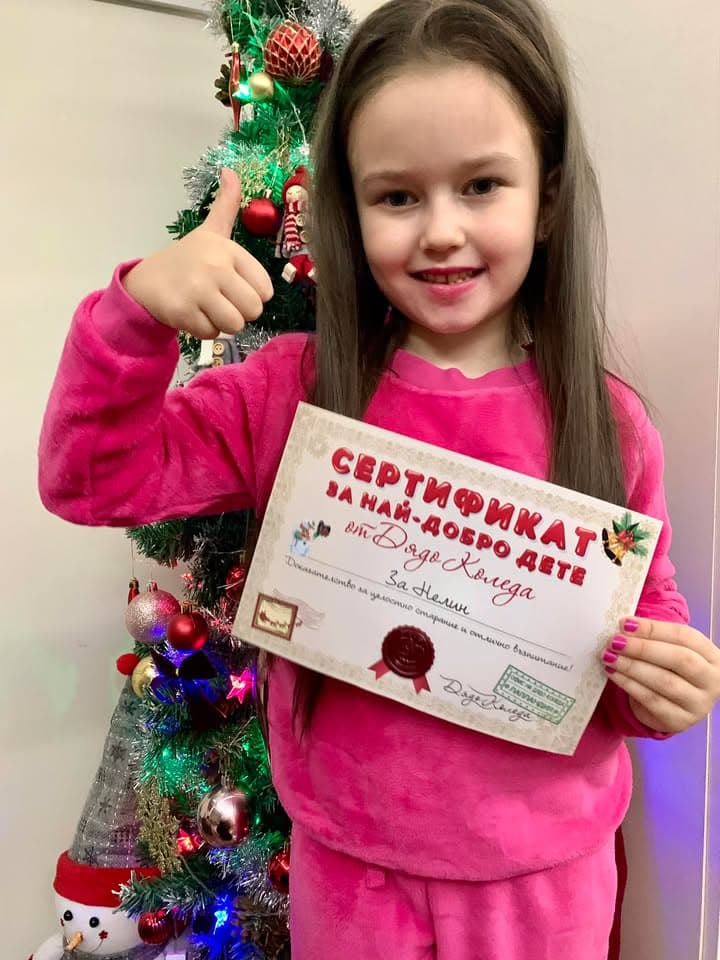 Усмихнато дете с коледен подарък